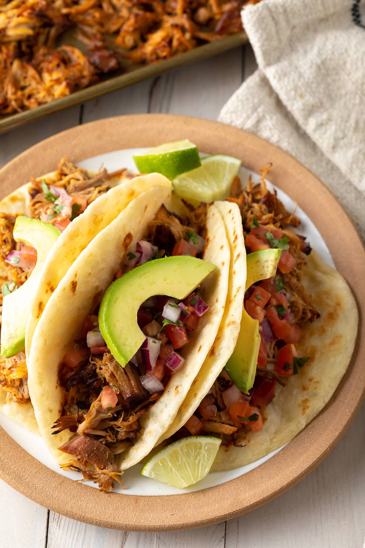 Slow-Cooker-Carnitas-Recipe Carnitas tacos with toppings on a plate.
