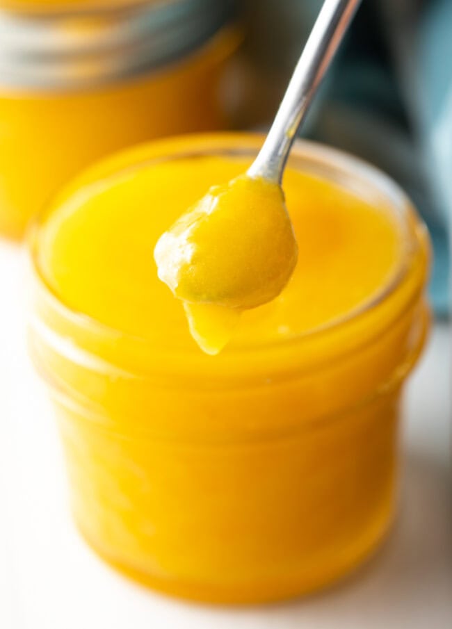 Orange Curd Recipe - Spoon holding orange curd to camera.