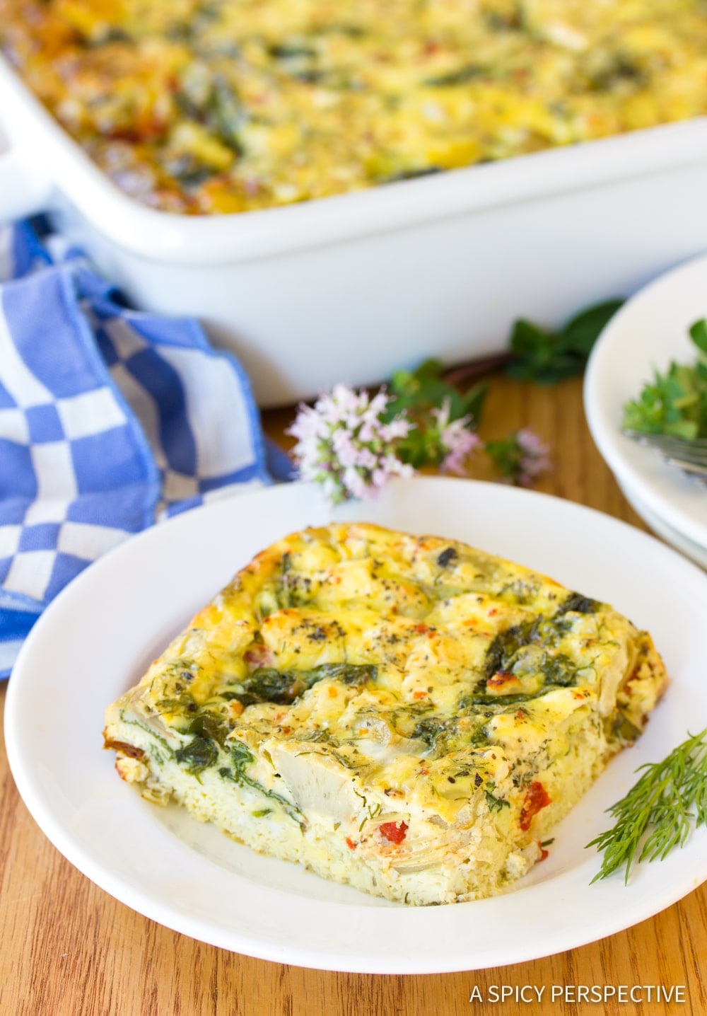 A close up photo of a slice of Greek omelette casserole on a white plate.
