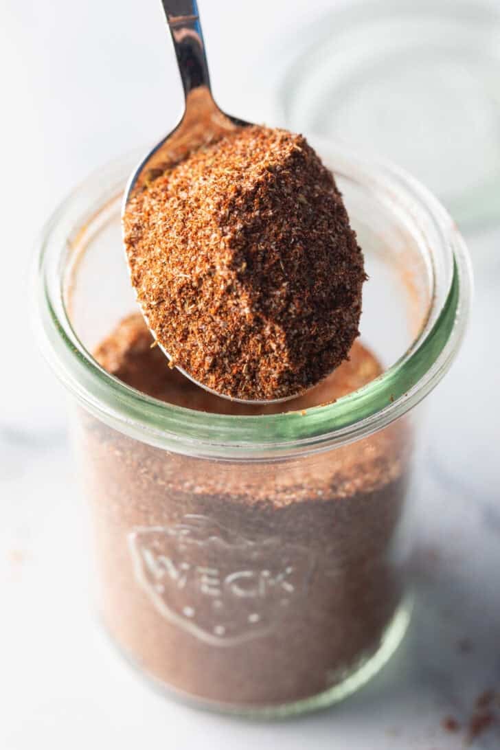 Spoonful of chicken taco seasoning held to camera.