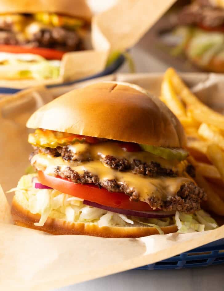 Easy Double Smash Burger on paper in a plastic tray with 2 patties and 2 slices of cheese.
