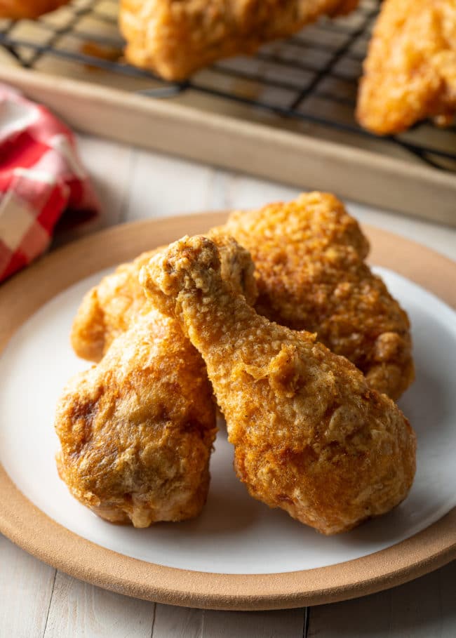 3 pieces of bread tavern fried chicken on a white plate.